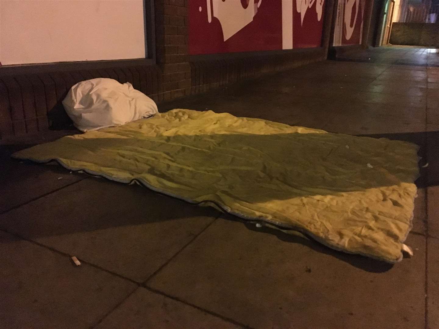 A neatly arranged sleeping bag and pillow outside Wilko