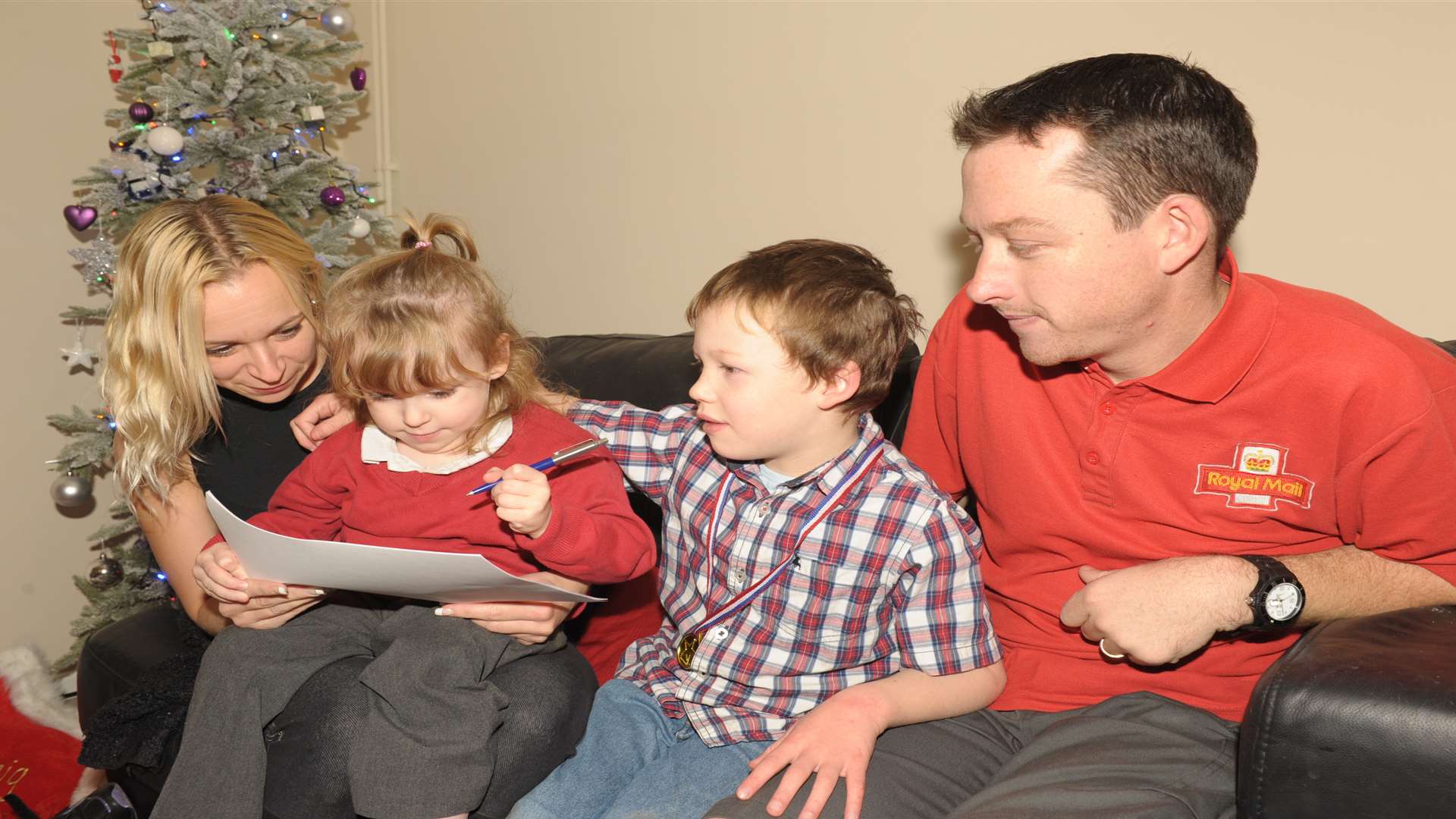 Paige writing her letter last year with mum Julie, brother Craig and father David.