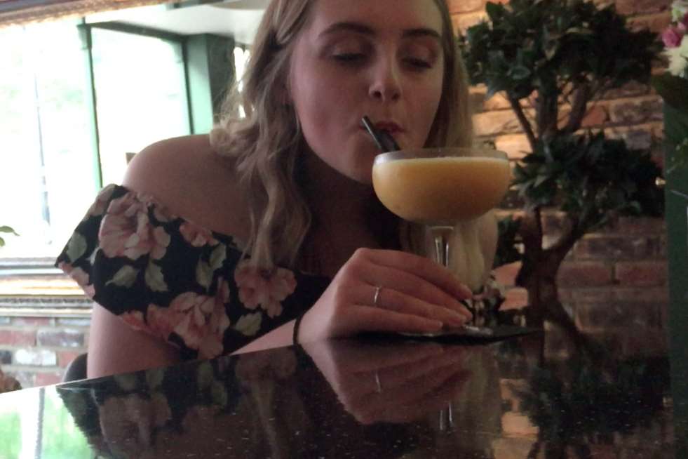 Nicole enjoys her first taste of a cocktail