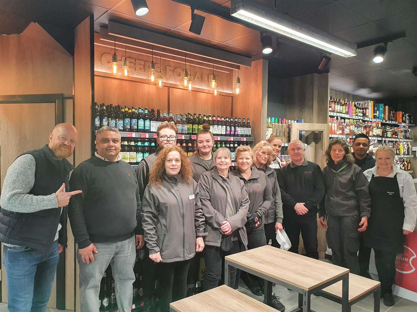 Jake Wood with the store's owner Peter Patel and staff