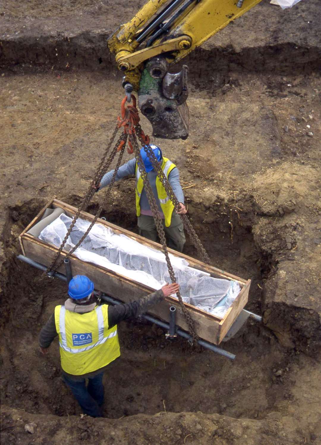 Lifting the coffin from Roman mausoleum at Grange Farm. Image from Pre-Constuct Archaeology