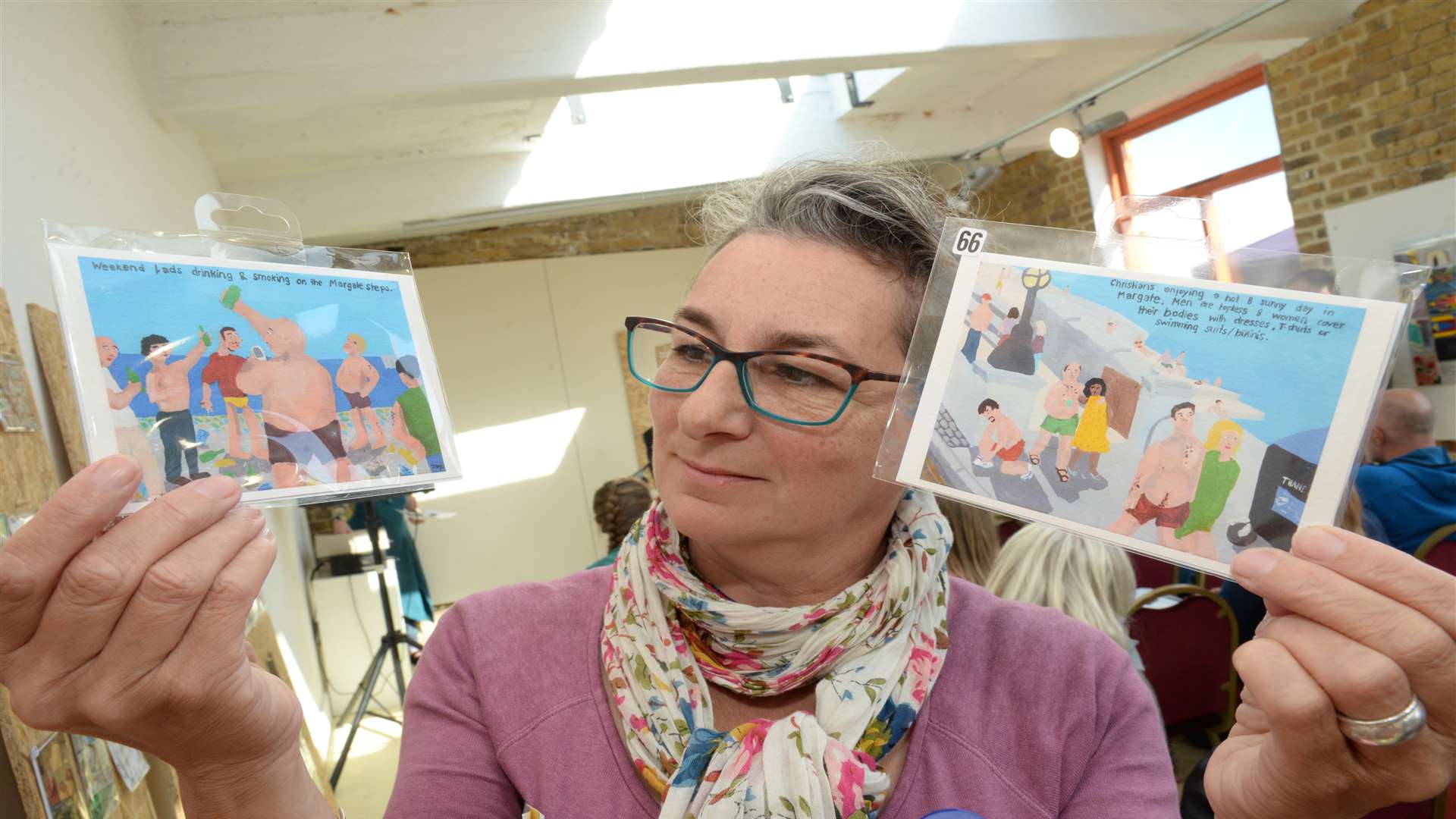 Jan Leandro of the Margate Caves Education Trust with two of the postcard's up for auction at the Harbour Arm Gallery, Margate on Saturday. Picture: Chris Davey