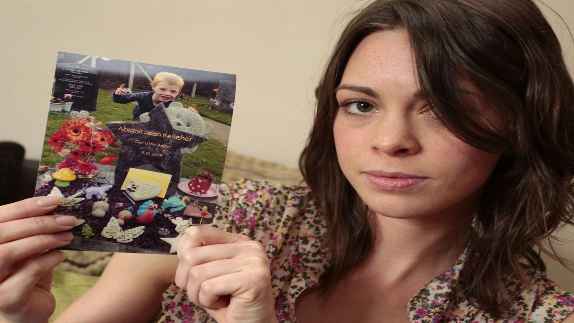Sarah Beckley with a photo of her daughter's grave. Picture: Martin Apps