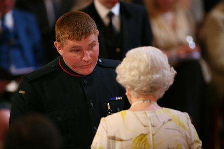 Rifleman Paul Jacobs receives his medal from Her Majesty The Queen