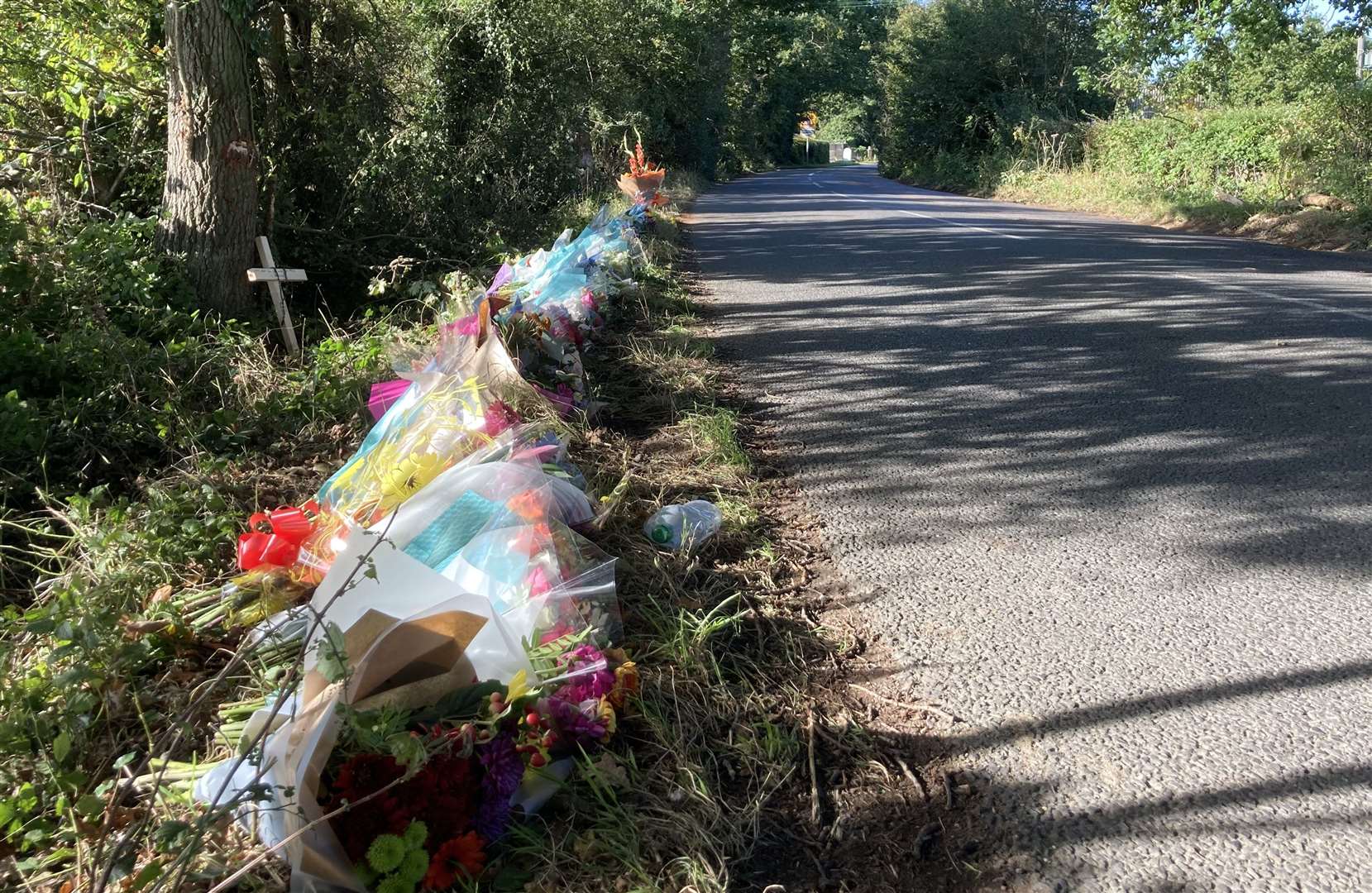 More than 50 floral tributes line Lenham Road, the scene of a crash which claimed four lives on Sunday, October 10