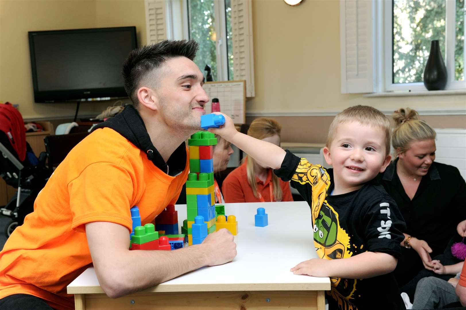 Tom Parker, from The Wanted, has fun with a young boy supported by hospice charity ellenor in 2015. Picture supplied by ellenor