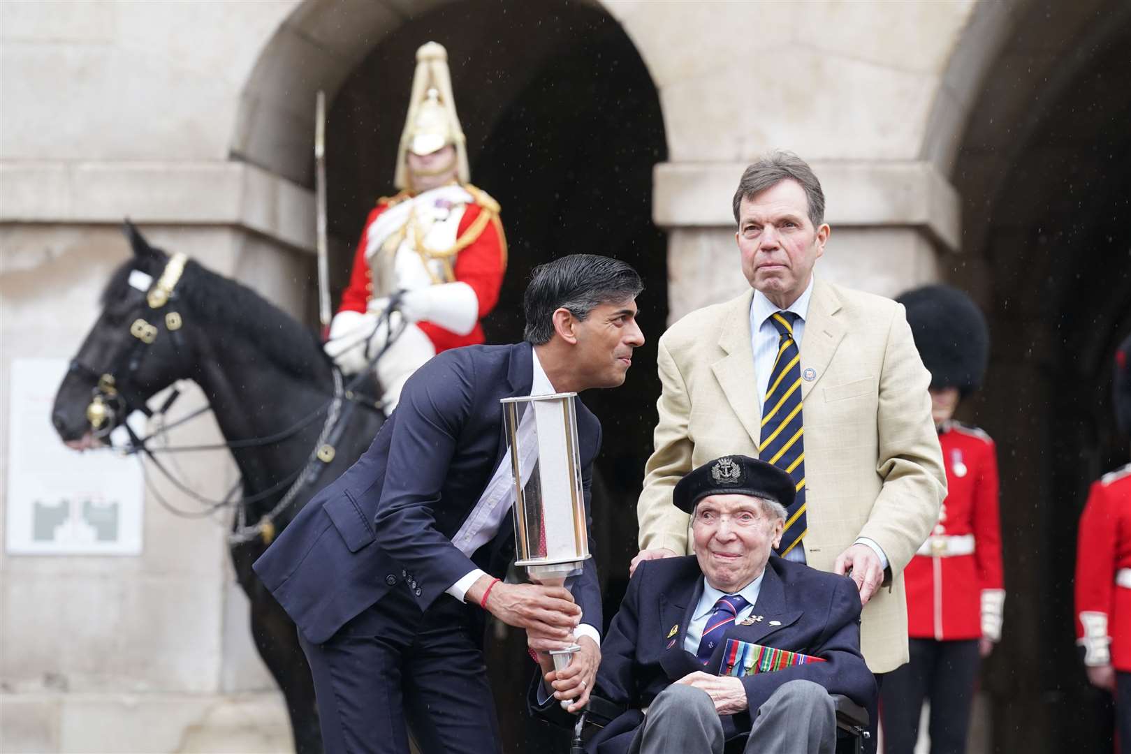 Prime Minister Rishi Sunak hands the Commonwealth War Graves Commission’s (CWGC) Torch of Commemoration to navy seaman D-Day veteran Peter Kent, 99, at Horse Guards, Whitehall (Stefan Rousseau/PA)