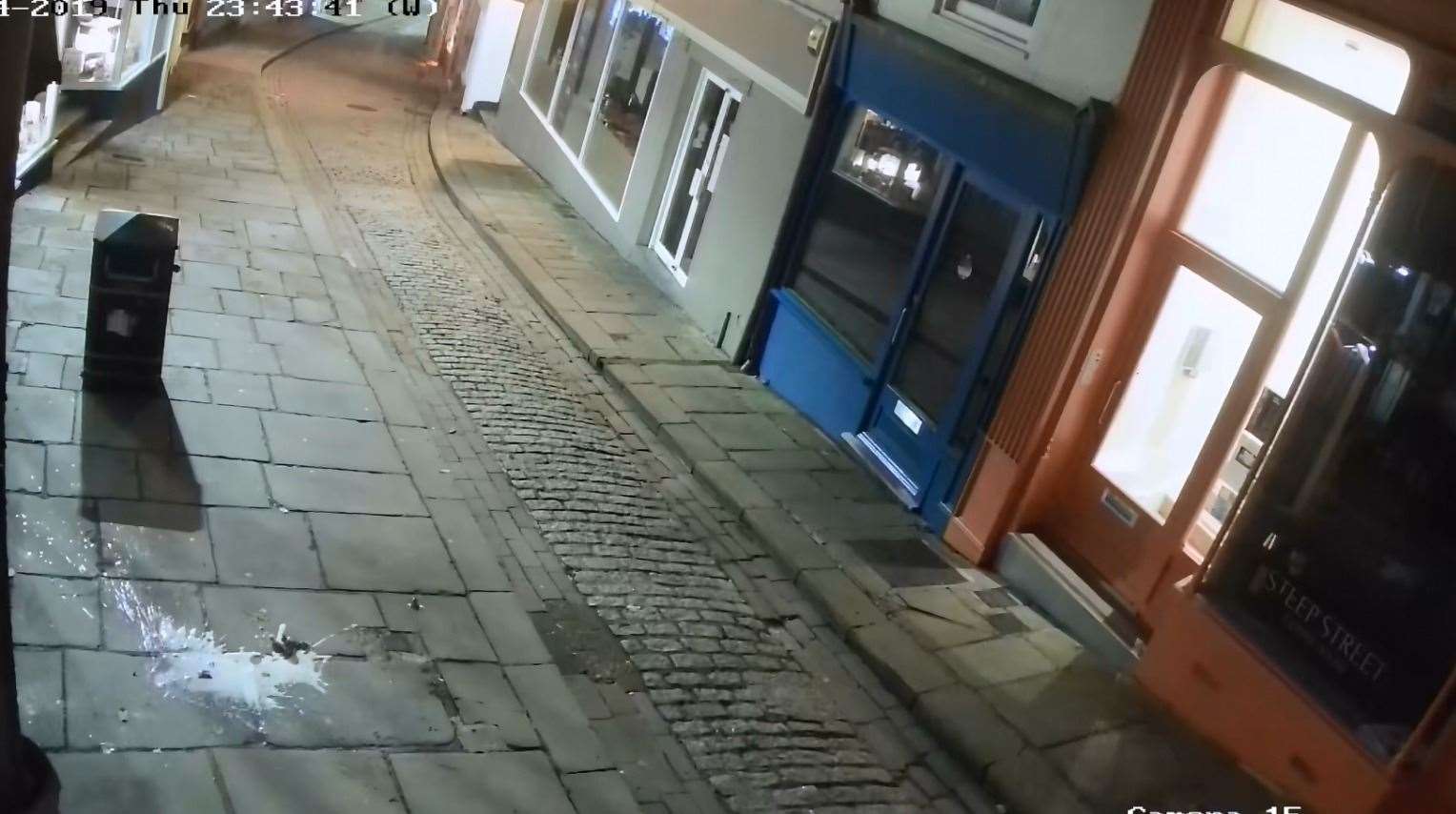 The broken beer bottle used to smash one of the windows can be seem on the ground