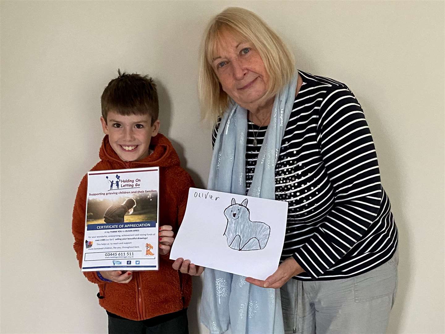 Debbie McSwiney, clinical lead from Holding on Letting Go, presented Oliver with a thank you certificate. Picture: HOLG