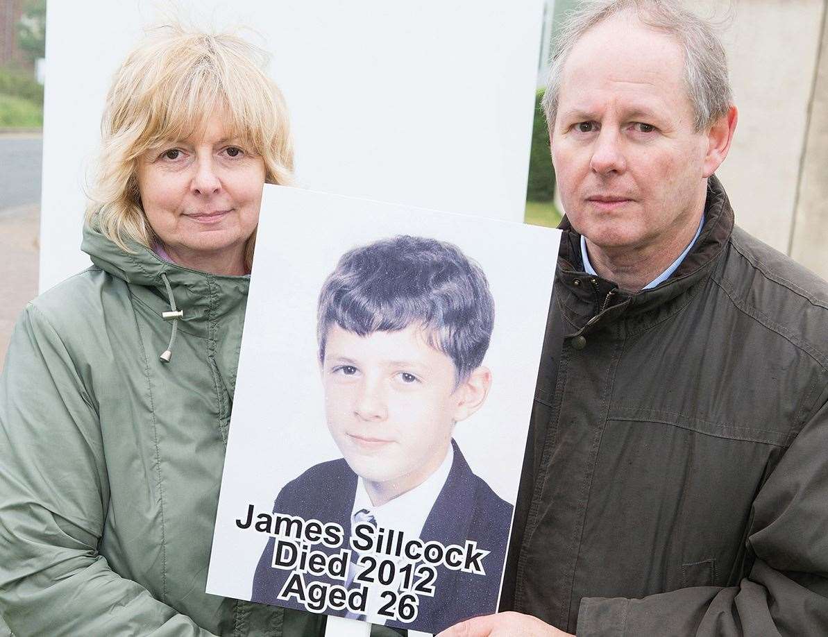 Lorraine and Melvin Sillcock holding a placard and photo of son James who took his own life after taking acne drug Roaccutane. Picture: Melvin Sillcock