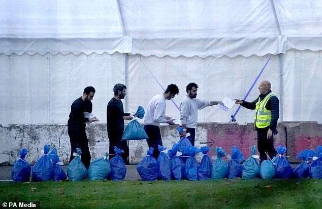 A group of people thought to be migrants gather their belongings before leaving the Manston immigration short-term holding facility. Photo: Gareth Fuller/PA