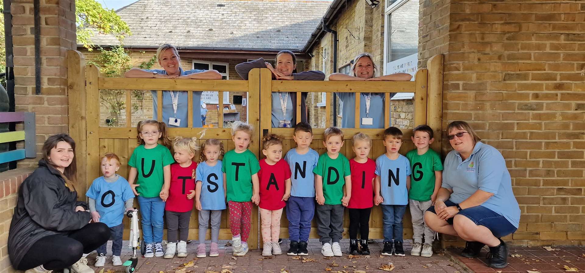 Staff and children celebrating Teddy Bear Day Care's 'outstanding' Ofsted result