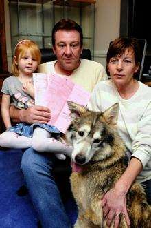 Georgina, 5, Mark and Rebecca Simmonds, of Halfway, with the refund claim forms and Takarra, their Northern Inuit dog