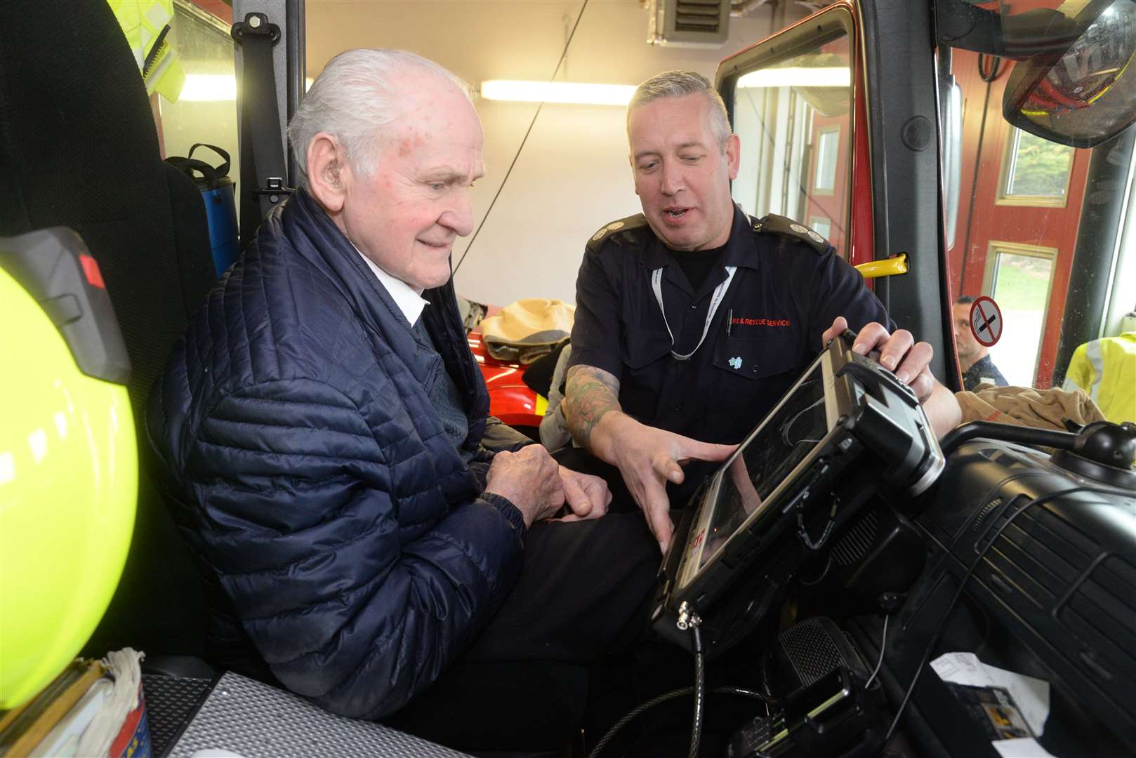 Former firefighter Doug Holgate with Watch Manager Neil Jones in the cab of one of the fire engines. Picture: Chris Davey