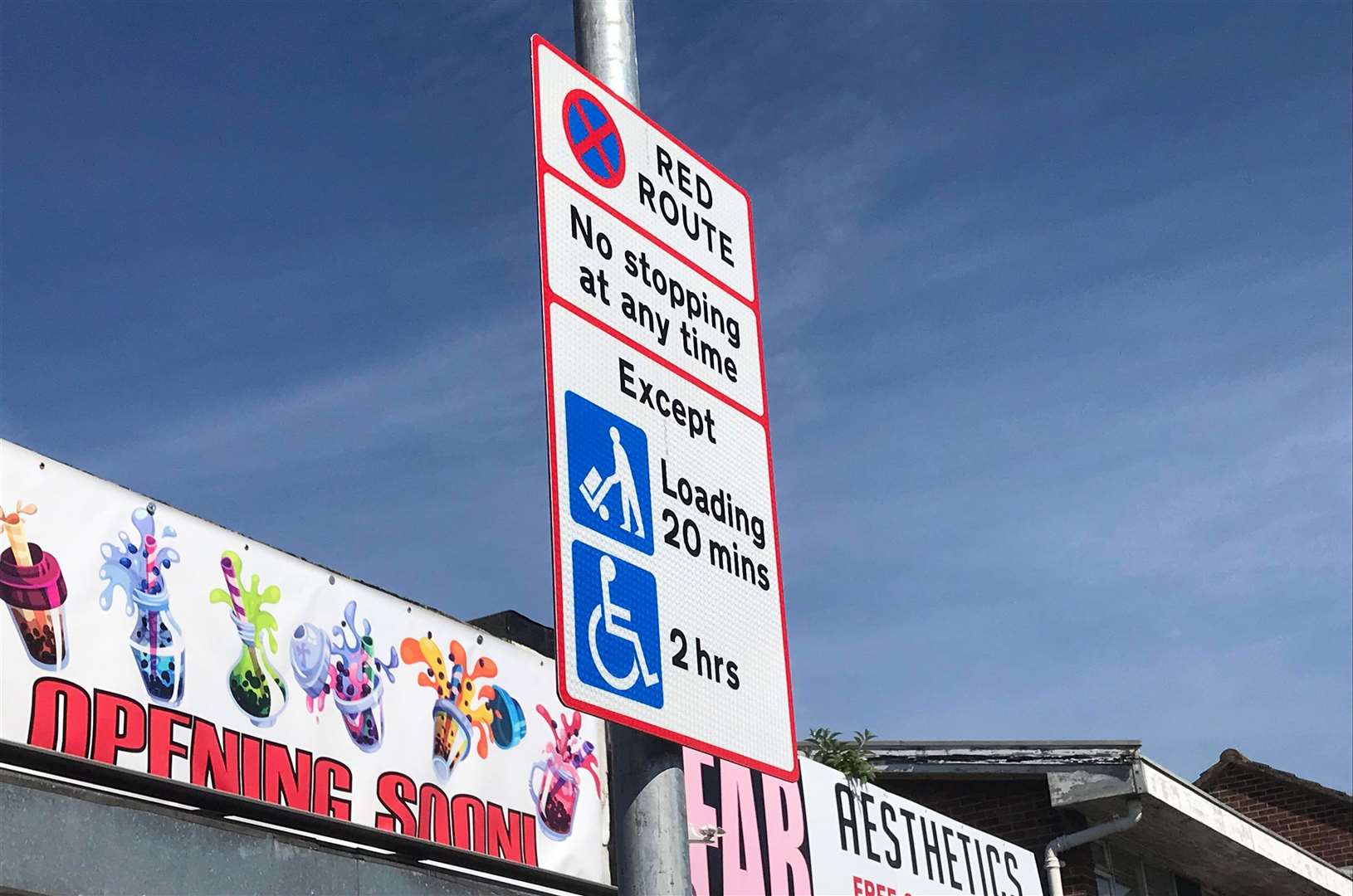 A red route sign in Rainham High Street for one of the loading bays.
