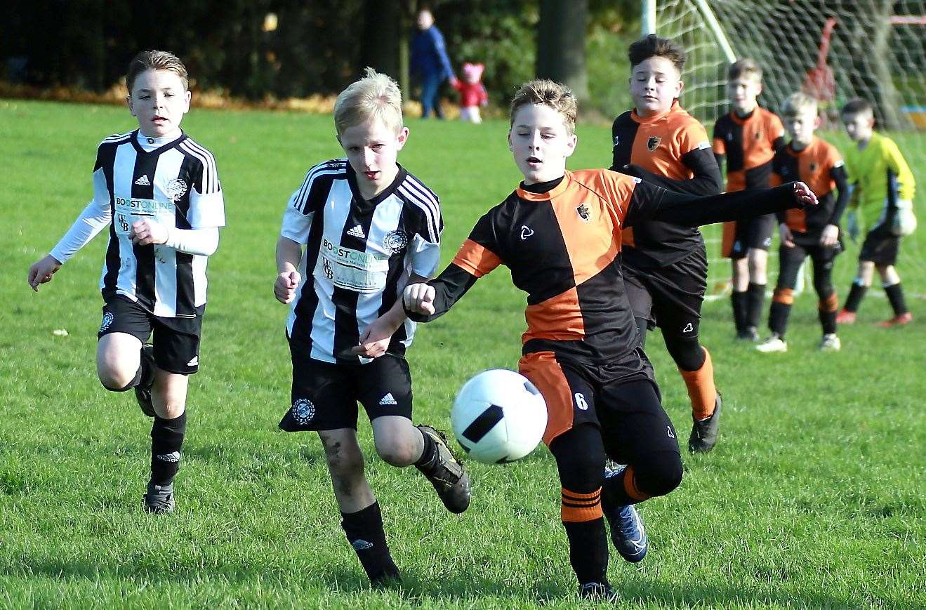 Pegasus 81 Flyers under-10s (orange/black) and Real 60 Panthers under-10s compete for possession Picture: Phil Lee