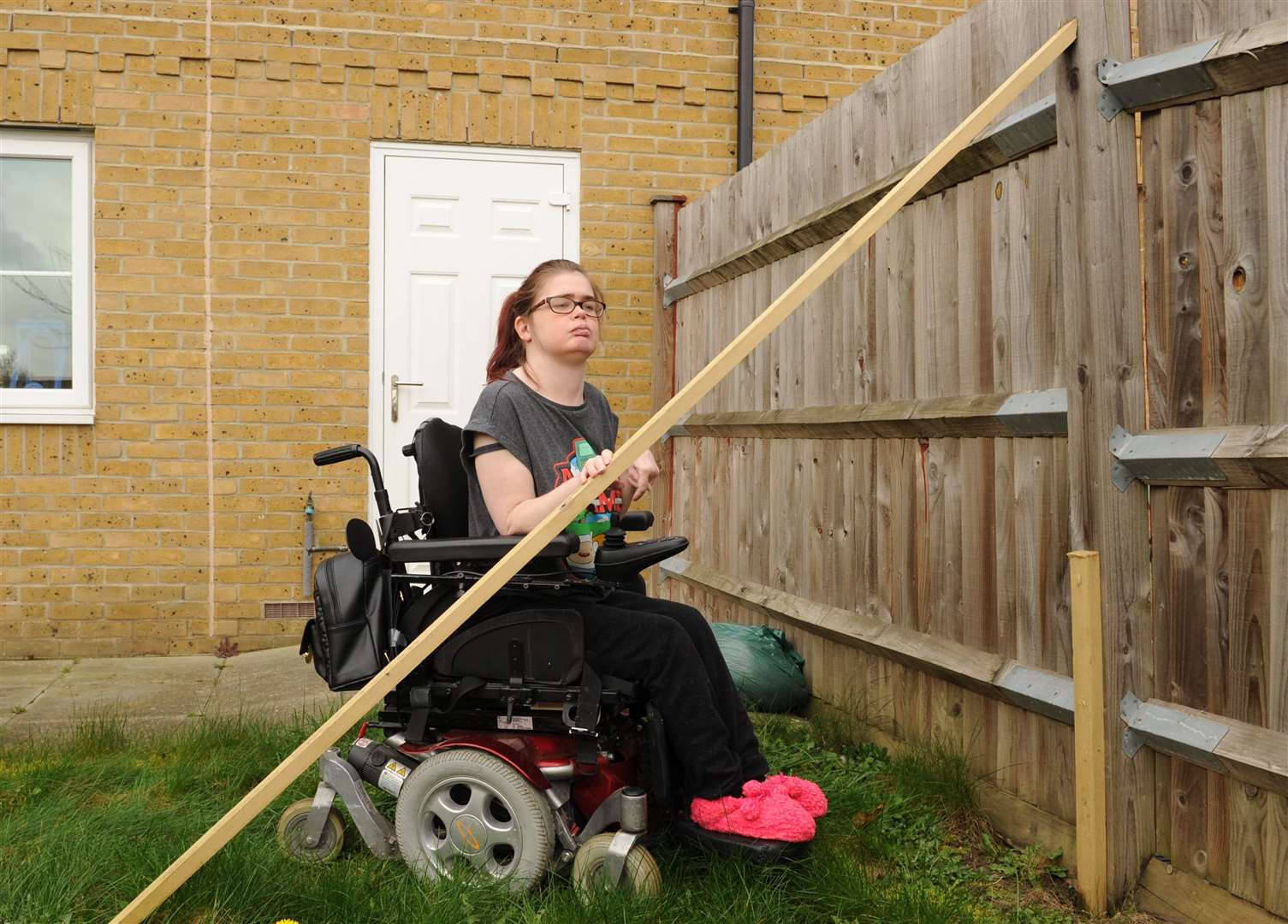 Hannah Haley-Cook with the badly-repaired fence at her home