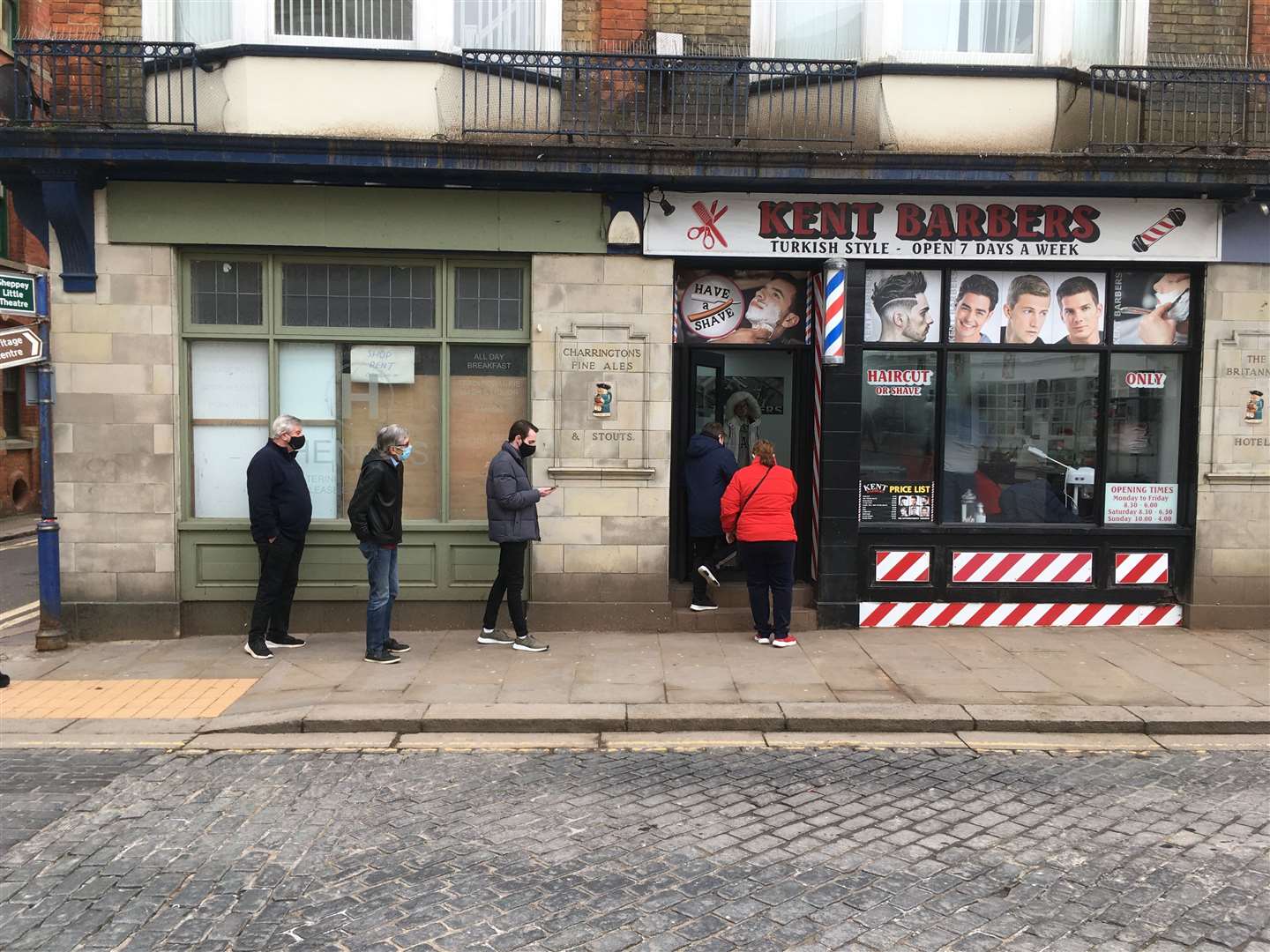 A queue outside Kent Barbers with its barber's pole working again in Sheerness High Street