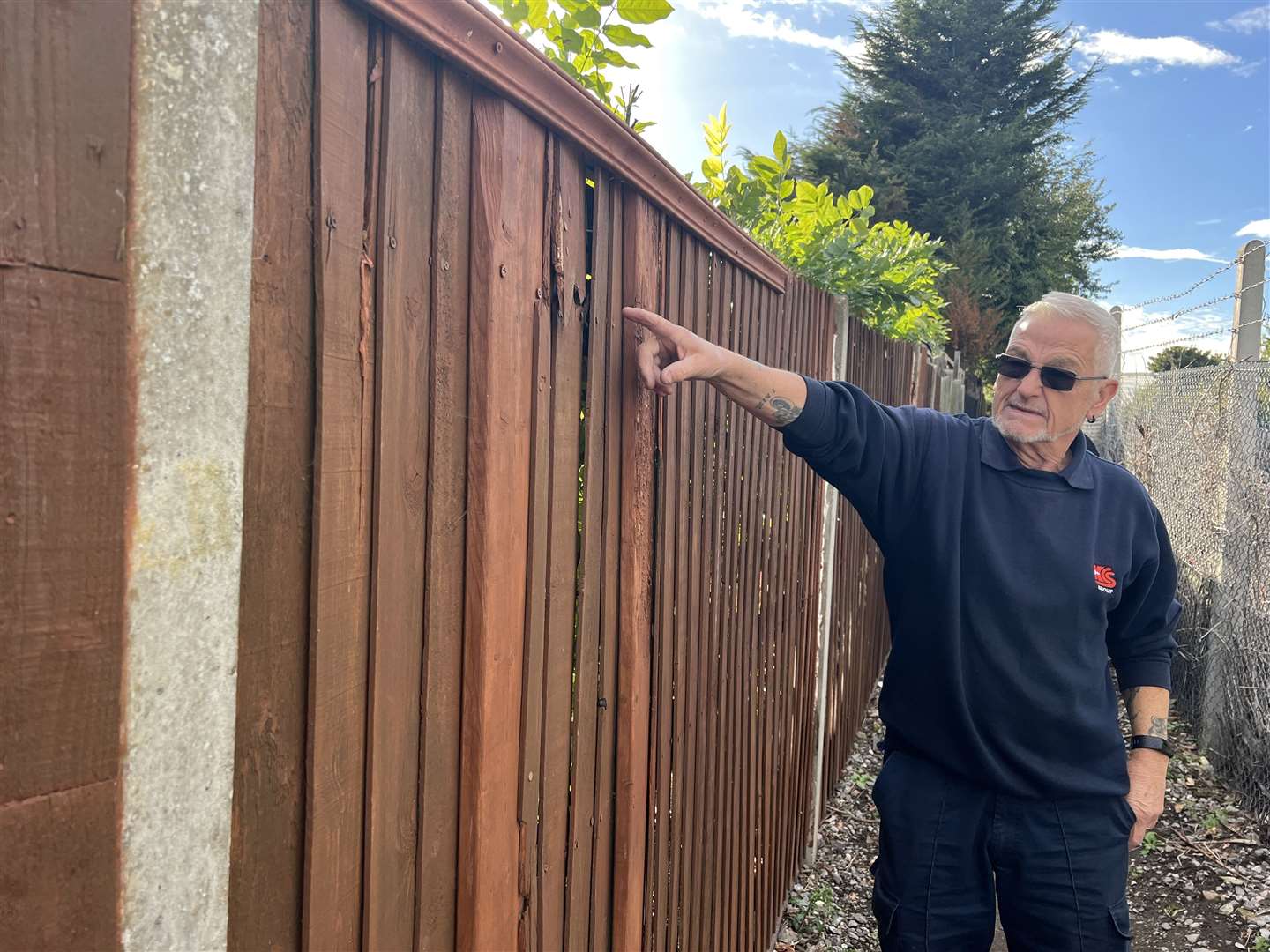 Clive Beach pointing to his fence in Coombe Drive which he has had to repair
