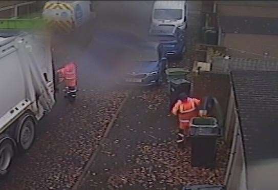 One of the binmen is seen emptying food waste in a recycling bin