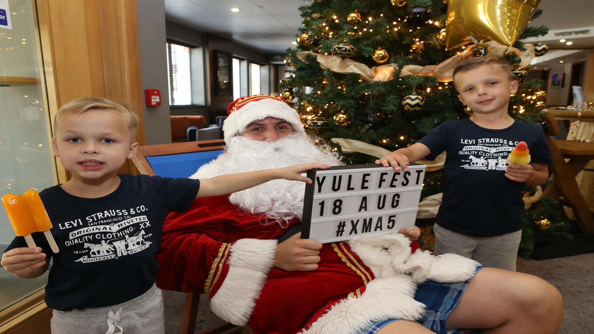 Ben Hughes, dressed as Santa, poses with John Smith, four, and his brother, Rocky, five, at The Village Hotel's Yule Fest during the launch of their Christmas parties