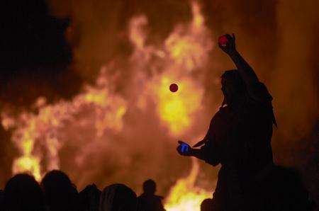 A juggler silhouetted against the burning sky at Biddenden blaze, bonfire and firework display. Picture: Gary Browne