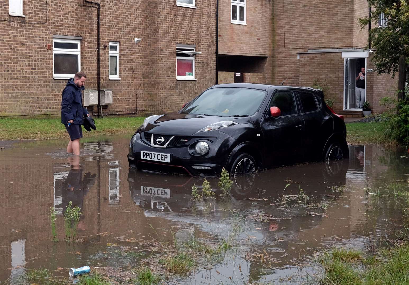 A man attempts to rescue his car in Taswell Road, Rainham, during last week’s torrential downpours Photo credit: Robin Halls