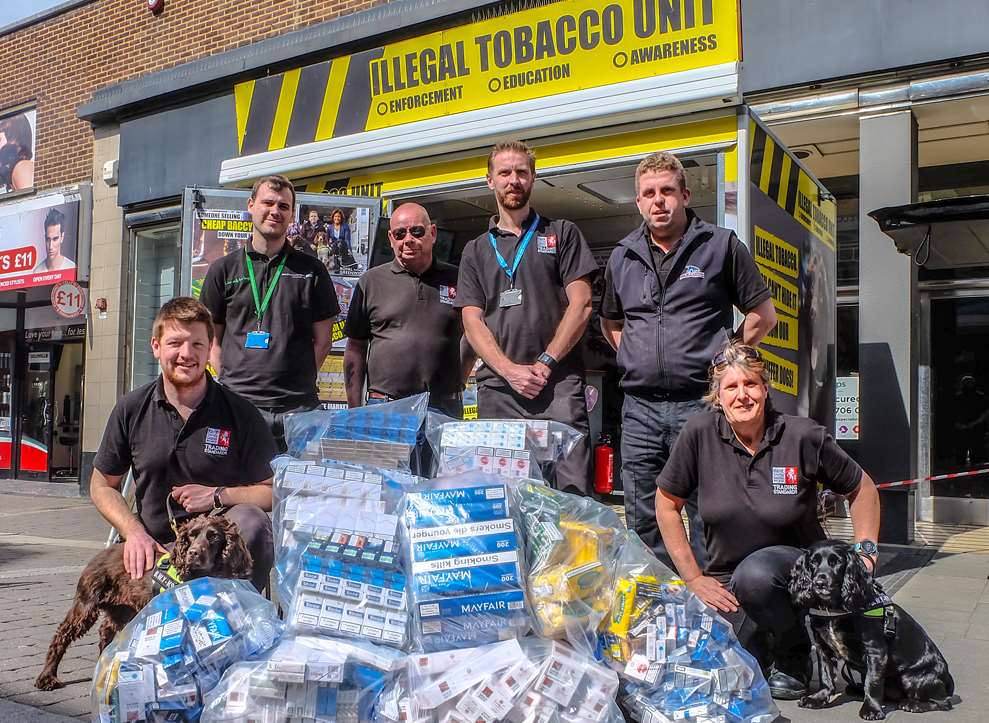 Kent Trading Standards officers with dog handler Stu Phillips, back right, Yoyo, Phoebe and the tobacco found in Dartford. Picture: BWY Canine Ltd