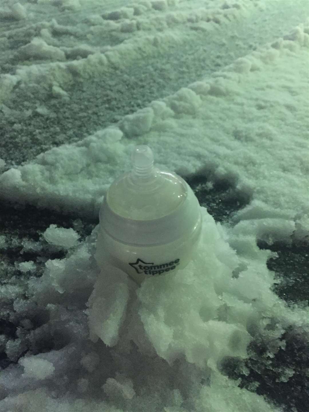 Baby Eva's milk bottle froze in the snow (6971019)