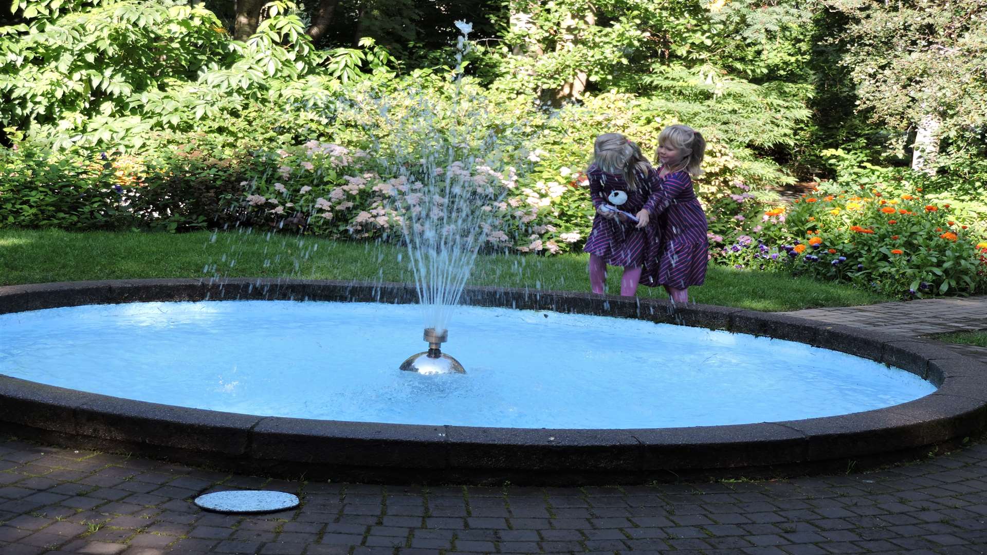 Alureyri Girls play by the pond at Lystigardur Garden