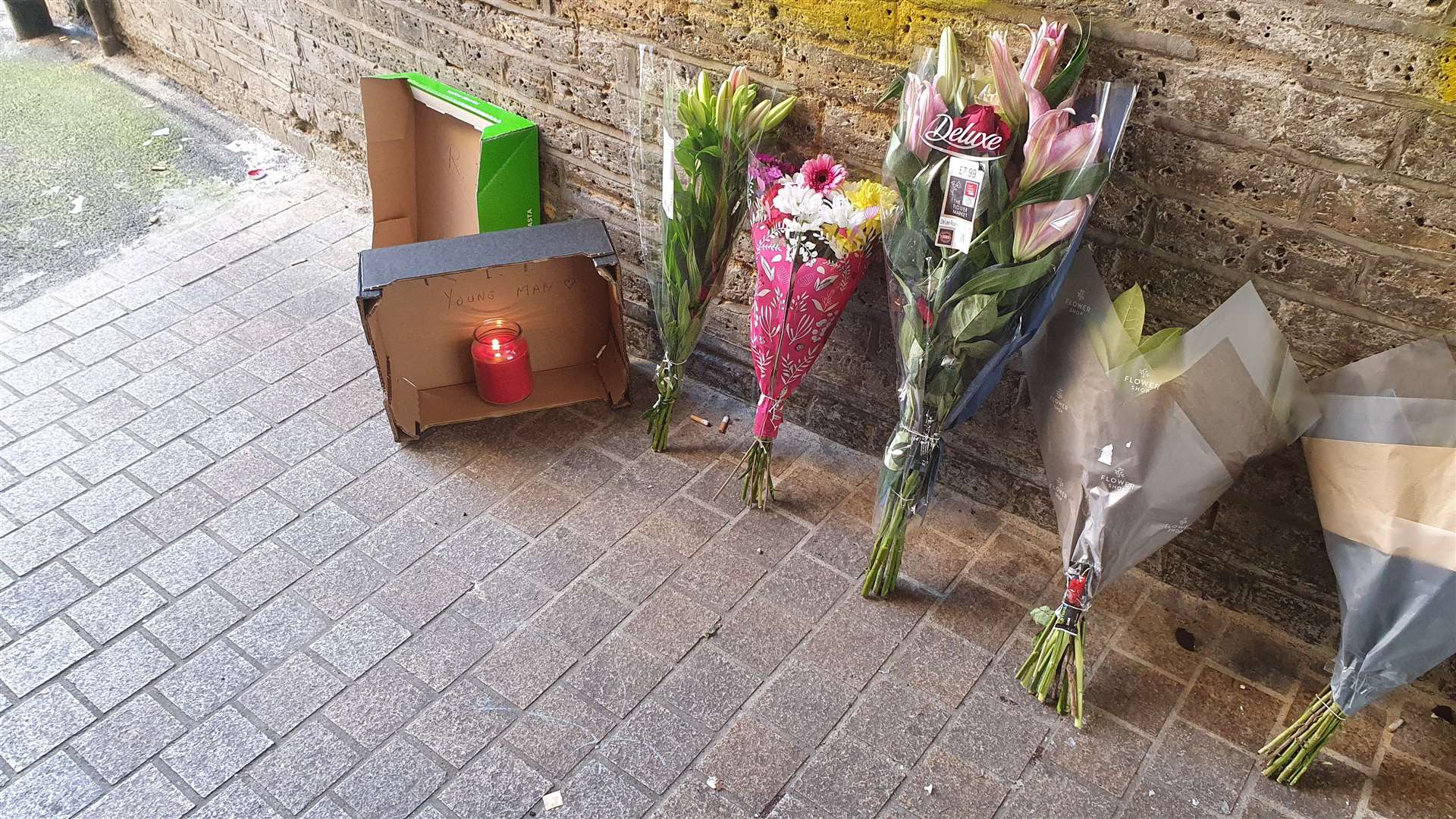 Tributes to an 18-year-old stabbing victim line the alleyway in Dartford High Street