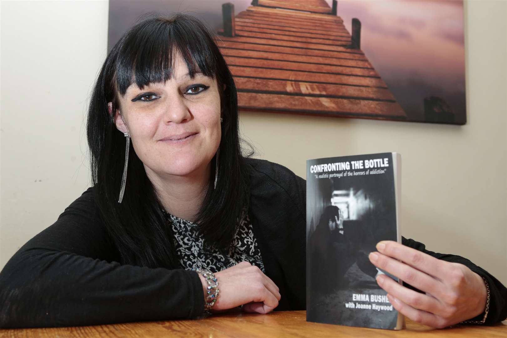 Recovering alcoholic Emma Bushen with the book she has written about her struggles with addiction