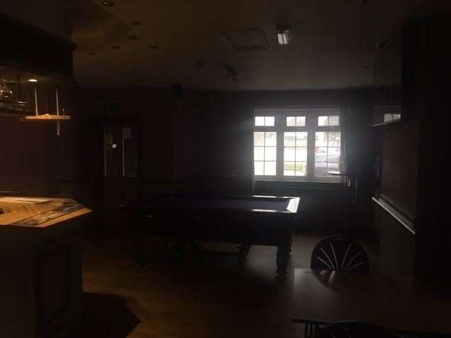 There were some lights on over the bar but not elsewhere in the pub – you might just be able to make out the purple baize on the pool table