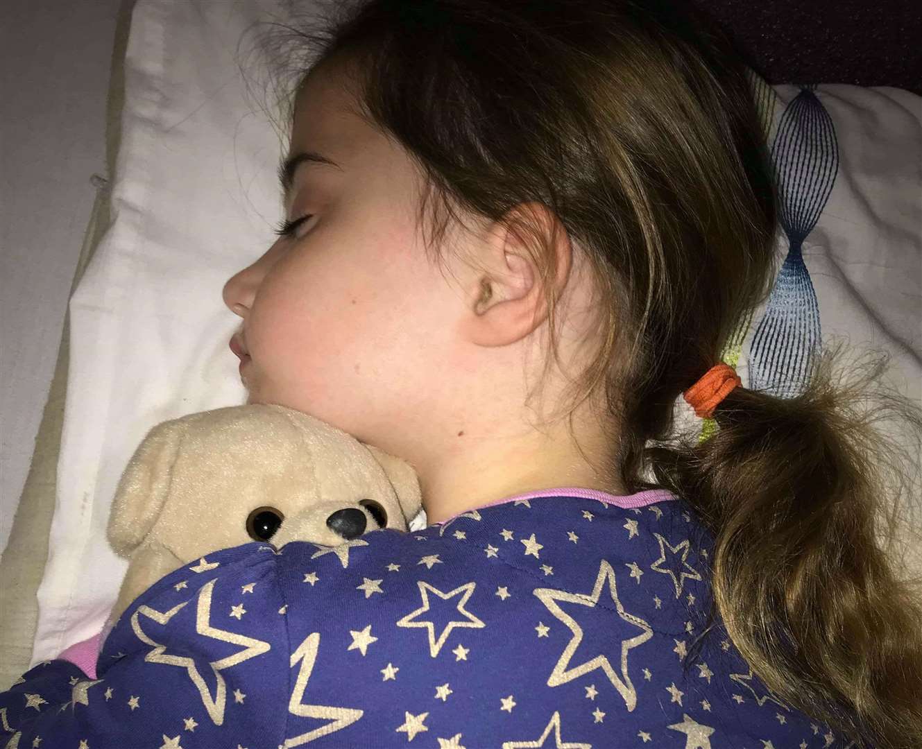 Eleanor sleeping with her favourite teddy for comfort after being knocked down by a motorbike
