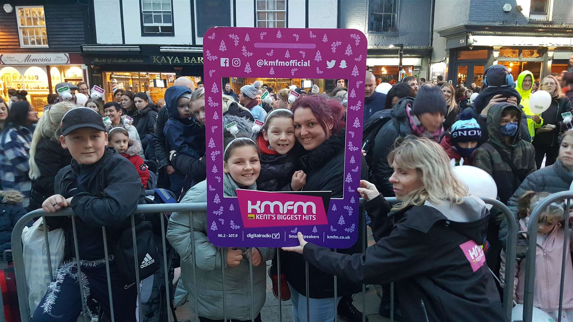 People posing with the KMFM selfie board