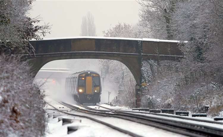 A Southeastern train makes its way through Ashford as rail services were disrupted by icy weather. Picture: Gareth Fuller/PA