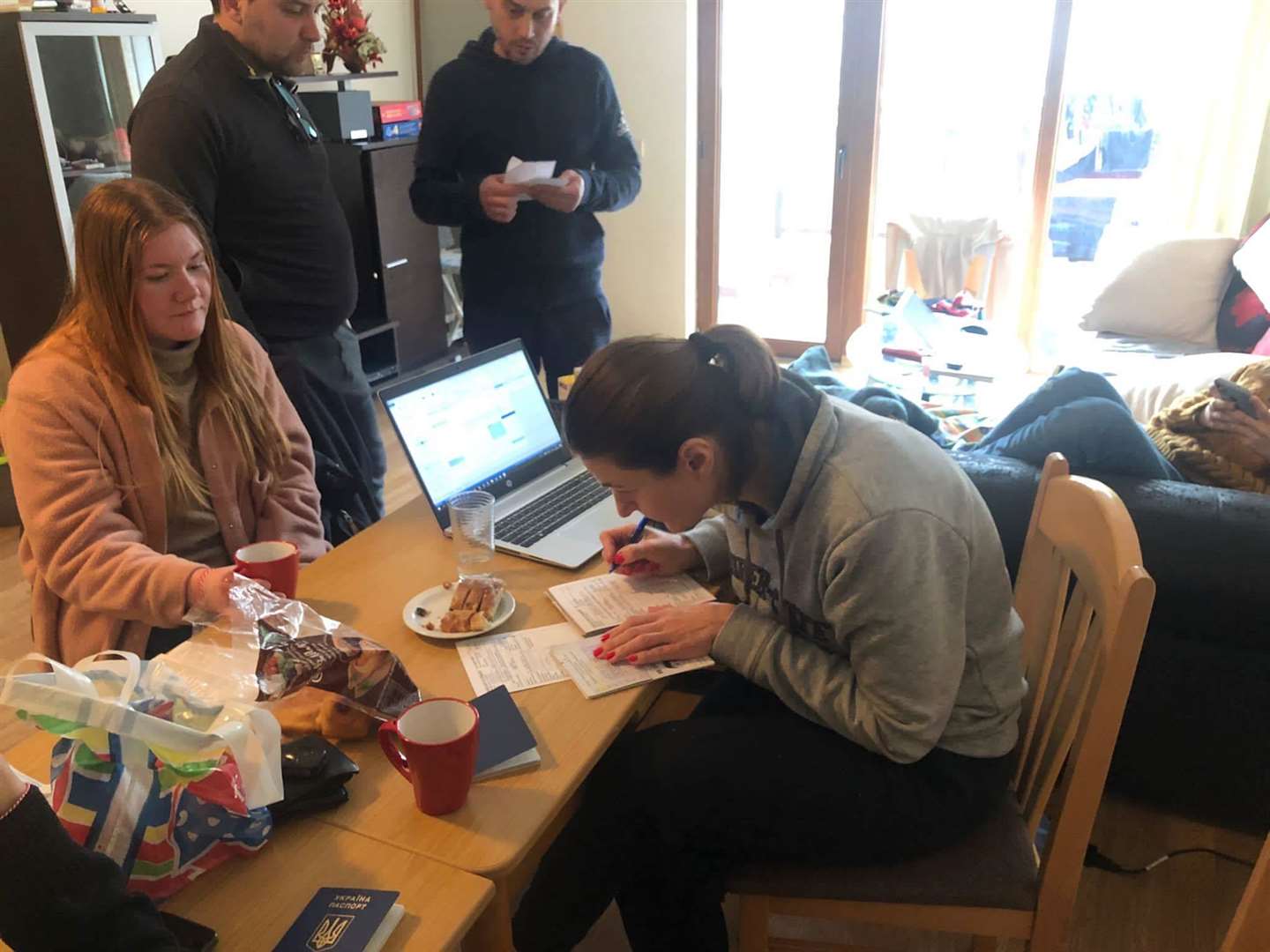 Ukrainian refugees signing immigration papers in one of Nathan Fenn's Bulgarian holiday apartments