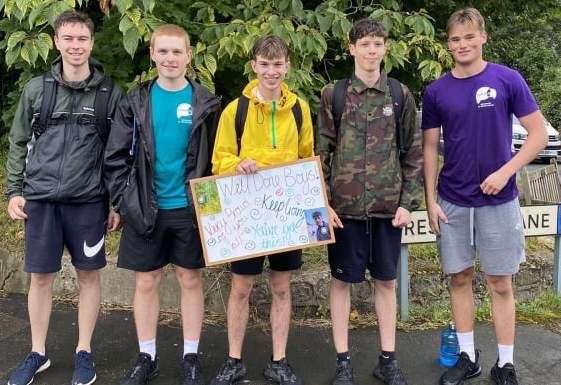 Evan Morgan, Jonathan Last, Harry, Miller, Thomas Kember and Owen Weller with a sign dropped off 20 miles in by Harry's girlfriend