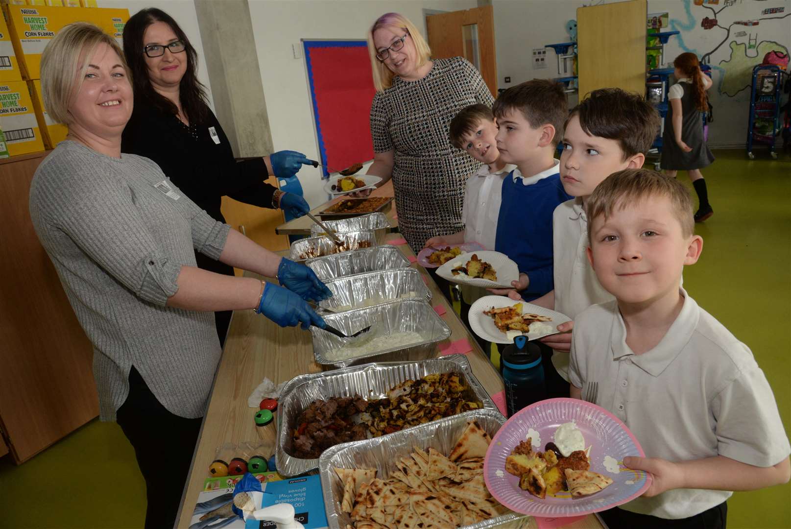 Inguna Mihailova and Aida Gremi of the Rose Cafe serve Year 3 pupils and teacher Clare James during the Greek food tasting at Halfway Houses, Primary School